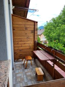 eine Holzbank und ein Hocker auf dem Balkon in der Unterkunft House Sara in Korenica