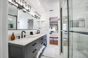 a white bathroom with two sinks and a shower at Shore Nuff in Jacksonville Beach