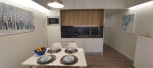 a kitchen with a white table and chairs in a room at Apartamento S. João in Alvor