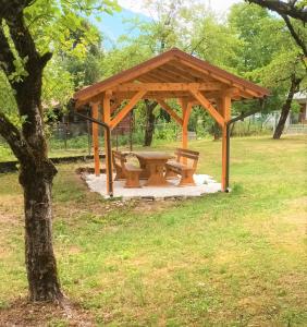 un refugio de picnic con una mesa de picnic en un parque en Apartment Veduta en Bovec