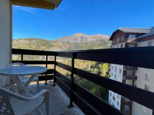 un balcone con tavolo e sedie e vista di Studio au Sauze avec balcon, 4 pers, parking - FR-1-165A-88 a Enchastrayes
