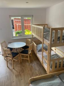 a room with a bunk bed and a table and chairs at Pokoje blisko morza in Sarbinowo