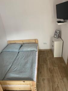 ein kleines Schlafzimmer mit einem Bett und einem TV in der Unterkunft Pokoje blisko morza in Sarbinowo