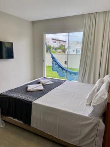 un grand lit dans une chambre avec une grande fenêtre dans l'établissement Santo Mar São Miguel do Gostoso, à São Miguel do Gostoso