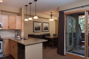 an open kitchen and dining room with a dining table at Lodges at Canmore in Canmore