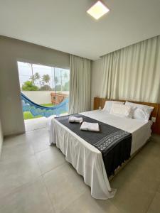 une chambre avec un grand lit avec des serviettes dessus dans l'établissement Santo Mar São Miguel do Gostoso, à São Miguel do Gostoso
