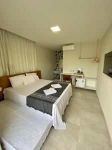 une chambre d'hôtel avec un grand lit et une cuisine dans l'établissement Santo Mar São Miguel do Gostoso, à São Miguel do Gostoso 16 autres photos