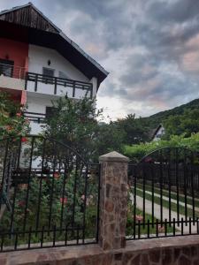 a gate in front of a house with a building at Casa Lica in Căciulata