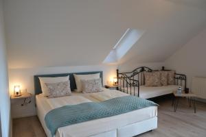a bedroom with two beds and two lamps in it at Christian Gartenhotel in Nieder-Olm