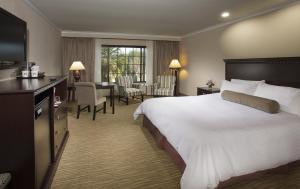 a hotel room with a large bed and a desk at Coast Anabelle Hotel in Burbank