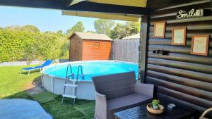 einen Hinterhof mit einem Pool, einem Stuhl und einem Tisch in der Unterkunft Wooden house corfu in Halikounas