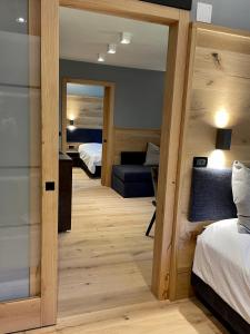 a room with two beds and a mirror at Hotel Rech-Hof Sayonara in Folgaria