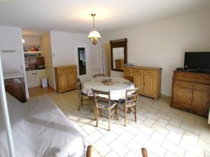 a living room with a table and chairs and a tv at Appartement Barcelonnette, 2 pièces, 4 personnes - FR-1-165A-99 in Barcelonnette