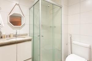 uma casa de banho com uma cabina de duche em vidro e um WC. em Beach Class Santa Maria by Easy Home no Recife