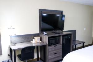 凤凰城Rodeway Inn Phenix City - Columbus的客房设有电视和带椅子的书桌 更多6张照片