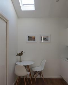 a white table and chairs in a room with a skylight at Twenty on Lake in North Avoca