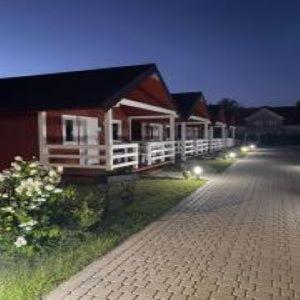 a row of cottages with lights on a street at Agromarko in Ustronie Morskie