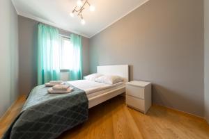 ein kleines Schlafzimmer mit einem Bett und einem Fenster in der Unterkunft Apartament z 3 sypialniami in Białystok