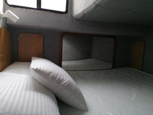 a bedroom with two beds and a mirror at Séjour insolite sur un yacht. Bateau Hôtel à quai. in La Rochelle