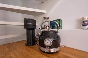 a tea kettle sitting on top of a wooden floor at Tiny Beachhouse Noordwijk in Noordwijk