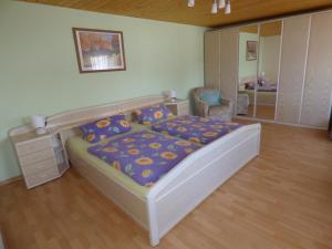 1 dormitorio con 1 cama y 1 silla en Ferienwohnung Dasch, bei Idar-Oberstein im Nationalpark Hunsrück-Hochwald, en Siesbach