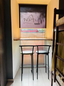 twee stoelen en een tafel in een kamer met een muur bij Le Rêve city hostel in Odessa