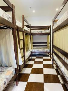 a room with three bunk beds and a checkered floor at Le Rêve city hostel in Odesa