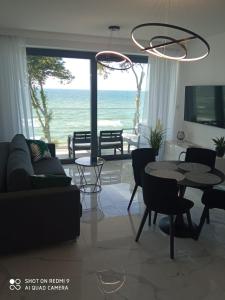 uma sala de estar com um sofá e uma mesa em Apartament z widokiem na morze w kompleksie Hevenia em Rewal