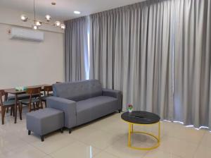 - un salon avec un canapé bleu et une table dans l'établissement New Cozy Mvista Homestay at Bayan Lepas Factory Area, à Bayan Lepas