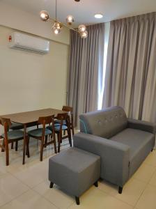 - un salon avec un canapé, une table et des chaises dans l'établissement New Cozy Mvista Homestay at Bayan Lepas Factory Area, à Bayan Lepas