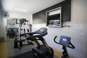 un gimnasio con 2 bicicletas estáticas y TV de pantalla plana en Locking's Barro Preto 6, en Belo Horizonte