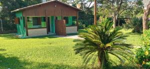 a small house with a palm tree in a yard at Chalés Jardim da Serra in Serra do Cipo