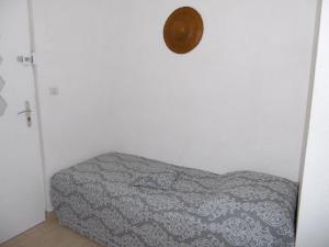 a bedroom with a bed and a clock on the wall at Appartement Sète, 2 pièces, 3 personnes - FR-1-472-159 in Sète