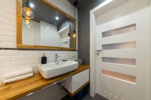 łazienka z umywalką i lustrem w obiekcie VIP Apartamenty Białystok w mieście Białystok