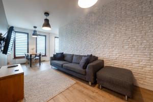 salon z kanapą i ścianą z cegły w obiekcie VIP Apartamenty Białystok w mieście Białystok