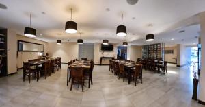 uma sala de jantar com mesas, cadeiras e luzes em Spark Hoteles em Antofagasta
