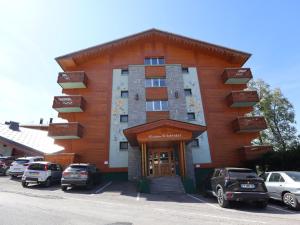 a building with cars parked in front of it at Appartement cosy près du centre et des pistes avec balcon, parking, 6 couchages - FR-1-623-305 in Les Gets