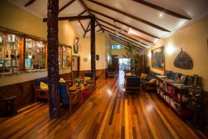 a room with wooden floors and a bar with tables and chairs at Tawali Leisure & Dive Resort in Alotau