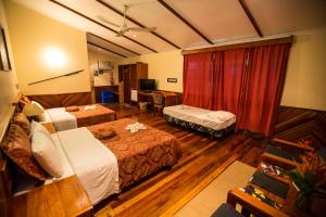 a hotel room with two beds and a desk at Tawali Leisure & Dive Resort in Alotau