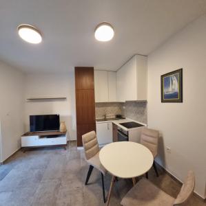 a kitchen and dining room with a table and chairs at Old town Apartments in Herceg-Novi +6 photos
