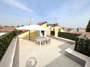 een patio met een tafel en een parasol op een dak bij ERMAN HOUSE Mansarda sulla Riviera del Brenta Venezia in Dolo