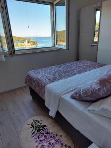 a bedroom with a bed with a view of the ocean at HOLIDAY HOME KATE in Vis