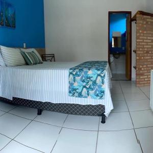a bedroom with a bed with a blanket on it at Pousada Cravo e Canela in Itaúnas +4 photos