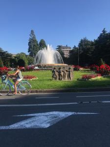 a woman riding a bike in front of a fountain at Apartamento PioXII Center in San Sebastián