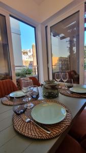 a table with plates and wine glasses on it at Old town Apartments in Herceg-Novi