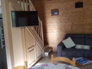 a living room with a couch and a flat screen tv at Chalet Barcelonnette, 4 pièces, 6 personnes - FR-1-165A-145 in Barcelonnette