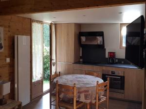 a small kitchen with a table and a refrigerator at Chalet rénové, cozy et bien équipé avec jardin - Proche Golf et Navette gratuite Pra-Loup - FR-1-165A-145 in Barcelonnette