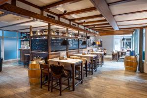 a restaurant with tables and chairs and a bar at Stadthotel im Kolpinghaus Lingen in Lingen