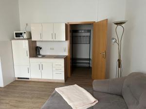 een woonkamer met een bank en een keuken bij Ferienwohnung im Mehrfamilienhaus in Weißwasser