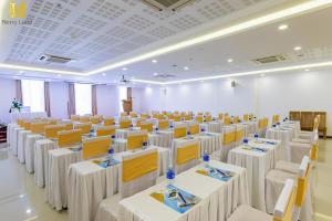 a large room with white tables and chairs at Merry Land Hotel Da Nang in Danang